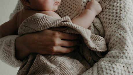 a baby with crocheted blanket